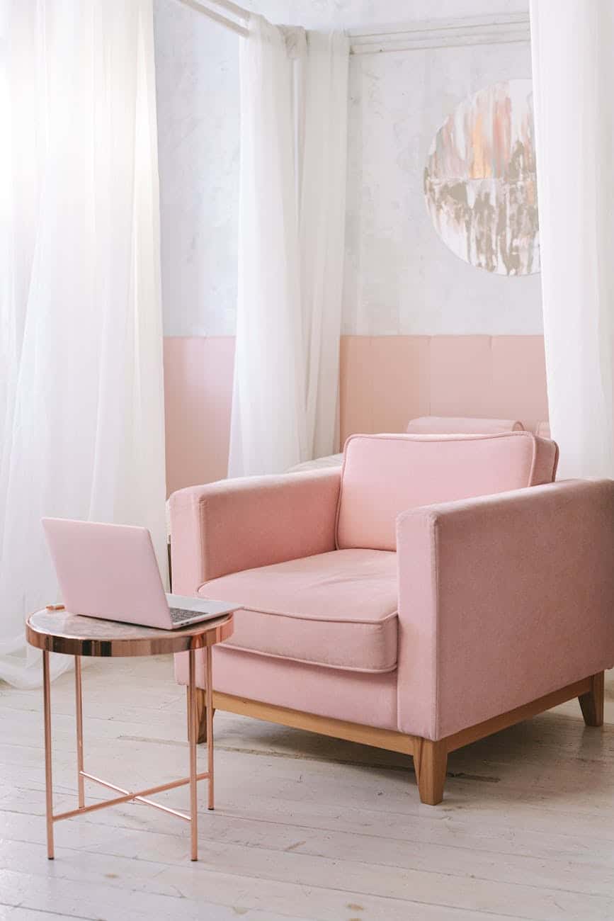 pink sofa chair near white curtains